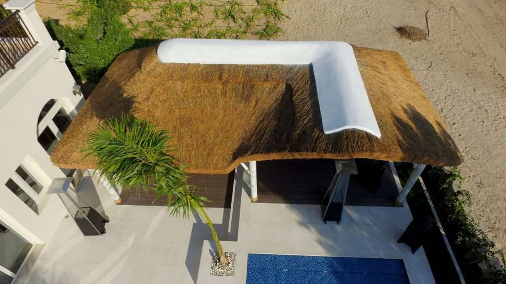 Outdoor living space with thatched roof poolside