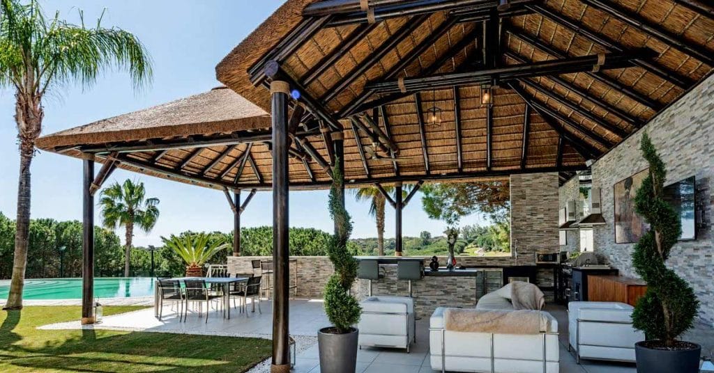 A bespoke thatched gazebo with an outdoor kitchen.