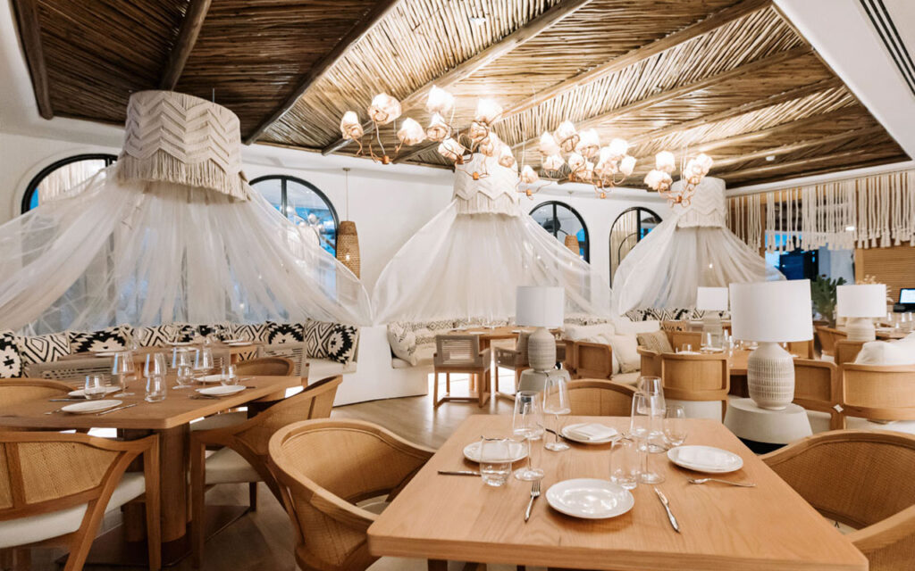 Eva Beach Club interior with Cape Reed lath ceiling, macrame canopies and natural thatch roof at Palm West Beach, Dubai