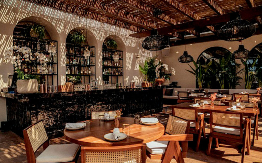 Outdoor dining and lounge area beneath bespoke timber pergolas at Gitano Dubai
