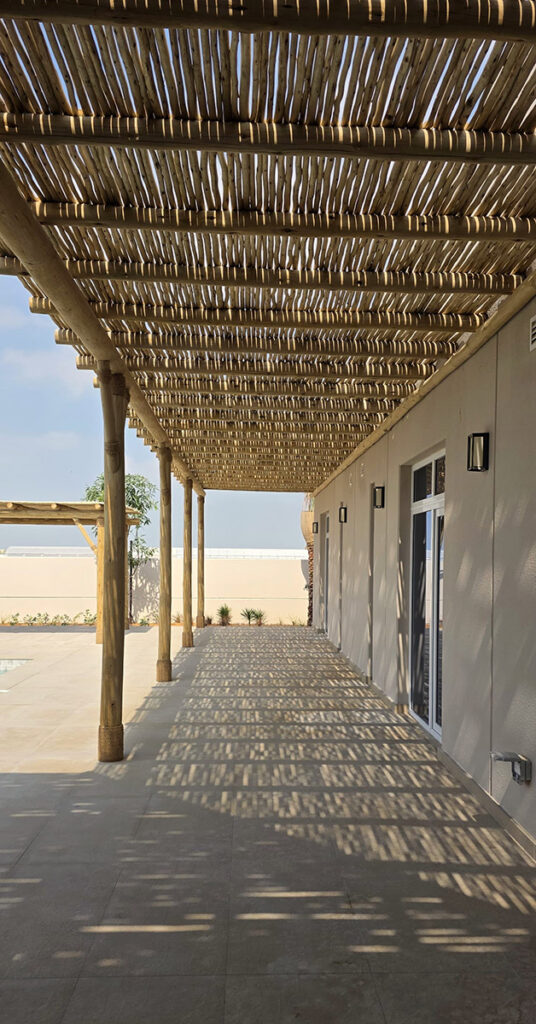 Covered timber walkway pergola along villa exterior, Abu Dhabi