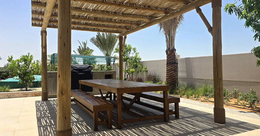 Open timber lath roofing filters Abu Dhabi's sun into soft, moving shade.